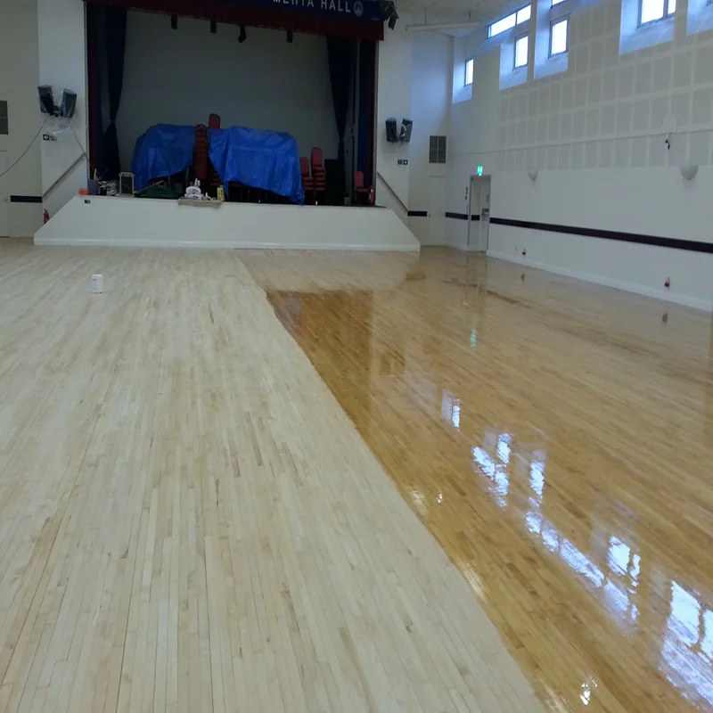 Glossy wood floor partially refinished in hall.