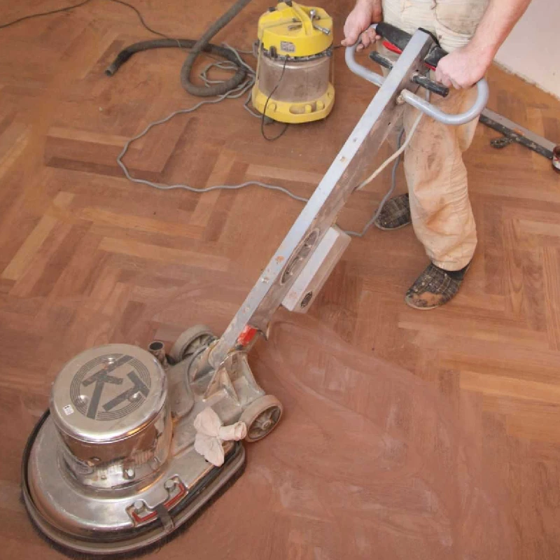 floor sanding machine actively grinding a wood floor laid